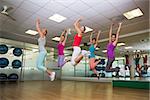 Fitness class jumping up in studio at the gym