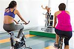 Spin class working out with motivational instructor at the gym