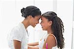 Pretty mother hugging her daughter at home in bathroom