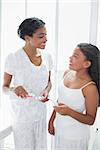 Pretty mother brushing her teeth with her daughter at home in bathroom