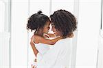 Cute little girl hugging her mother at home in the bathroom