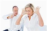 Older couple sitting in chairs arguing on white background