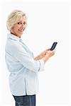 Happy mature woman sending a text on white background