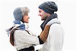 Attractive young couple in warm clothes hugging on white background