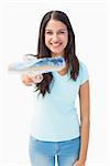 Happy young brunette holding paintbrush on white background