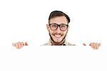 Geeky hipster showing poster smiling at camera on white background