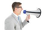 Geeky businessman shouting through megaphone on white background