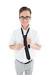 Geeky hipster fixing his tie smiling at camera on white background