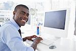 Happy businessman working at his desk in his office