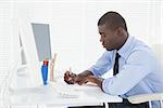 Handsome businessman working at his desk in his office