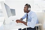 Focused businessman working at his desk listening to music in his office