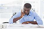 Serious businessman on the phone at desk in his office