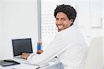 Happy businessman working at his desk in his office