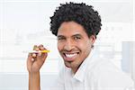 Happy businessman holding electronic cigarette in his office