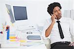 Serious businessman working at his desk on the phone in his office