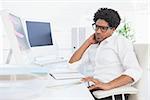 Hipster businessman working at his desk in his office