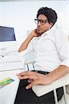 Hipster businessman working at his desk in his office
