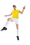 Football player in yellow jersey kicking on white background