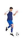 Football player in blue jersey kicking ball on white background