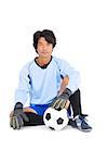 Goalkeeper in blue holding ball on white background