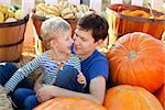 happy young father and his cute son spending fun time together at pumpkin patch; family of two at fall