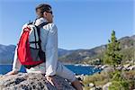 young healthy man resting at the top of the rock after hiking near lake tahoe, california, usa