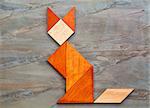 abstract picture of a cat built from seven tangram wooden pieces against slate rock background, a traditional Chinese puzzle game, the artwork copyright by the photographer