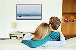 Couple watching television in living room