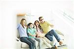 Family watching 3D television in living room