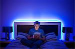 Man using digital tablet in bed