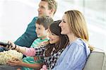 Family watching television in living room