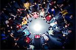 Business people forming circle around bright light