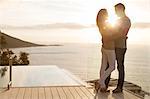 Couple on wooden deck overlooking ocean