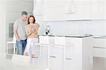 Couple using digital tablet in kitchen