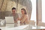 Couple using laptop at breakfast