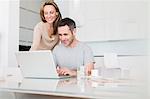 Couple using laptop at breakfast table