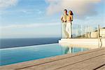 Couple on modern balcony overlooking ocean