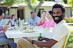 Man smiling at table outdoors