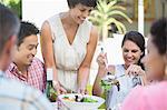 Woman serving friends at table outdoors