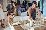 Woman serving food at dinner party