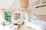 Chandelier and armchair in rustic bedroom