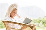 Woman in bathrobe reading outdoors