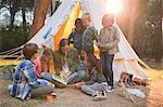 Teacher and students reading at campsite