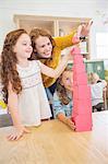 Students and teacher stacking blocks in classroom