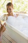 Couple toasting each other in bubble baths