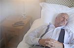 Businessman relaxing on bed in hotel room