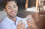 Man using cell phone in armchair