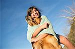 A girl in a beach towel with a golden retriever dog.