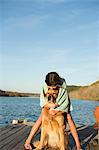 A girl cuddling a golden retriever dog.