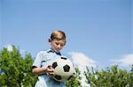 A young boy holding a soccer ball.